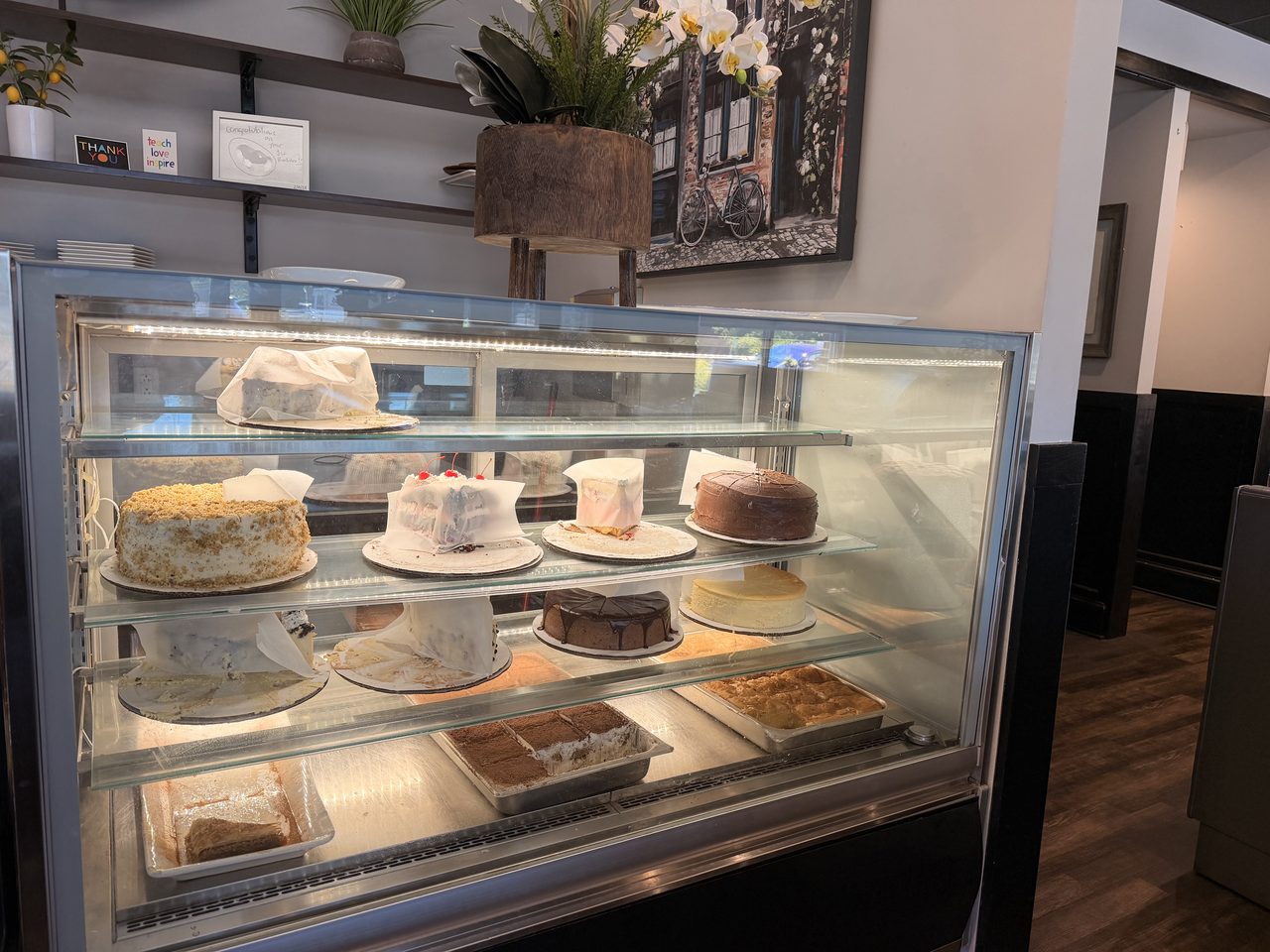 The pastry case at Four Seasons, lined with cakes and plants